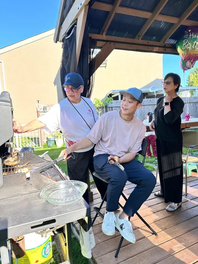 Ken and his parents at a backyard barbecue